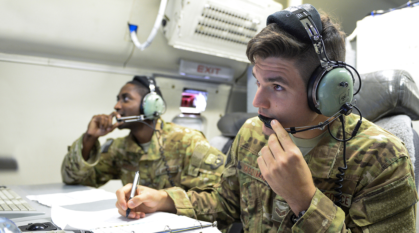 airman speaking on a headset and taking notes