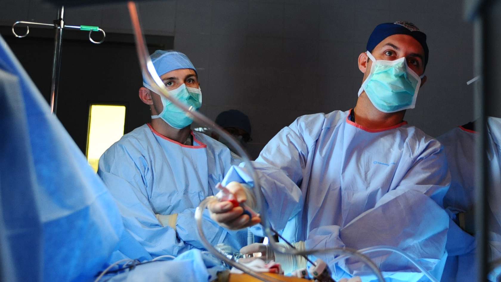 Two surgeons performing procedure on patient 