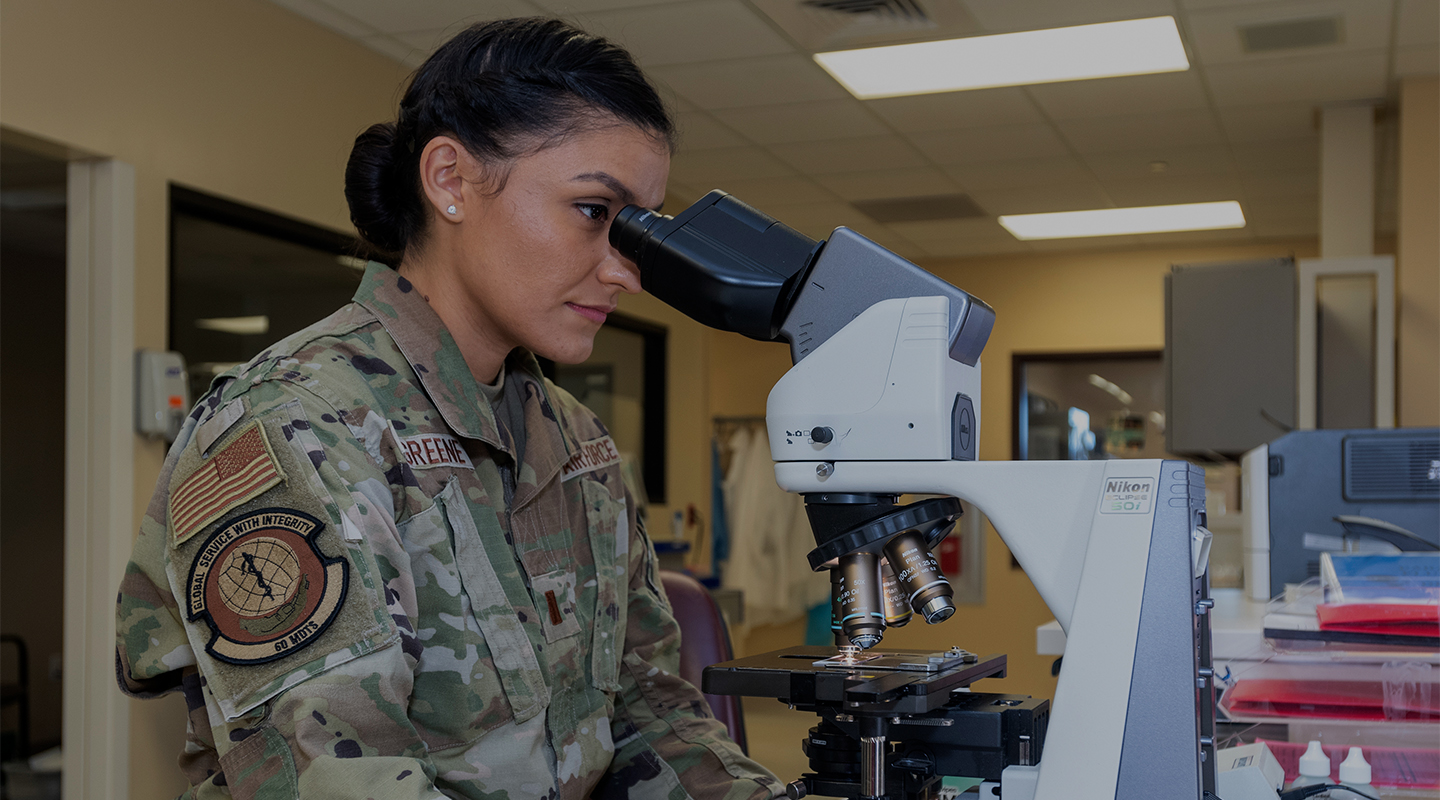 airman looking into microscope