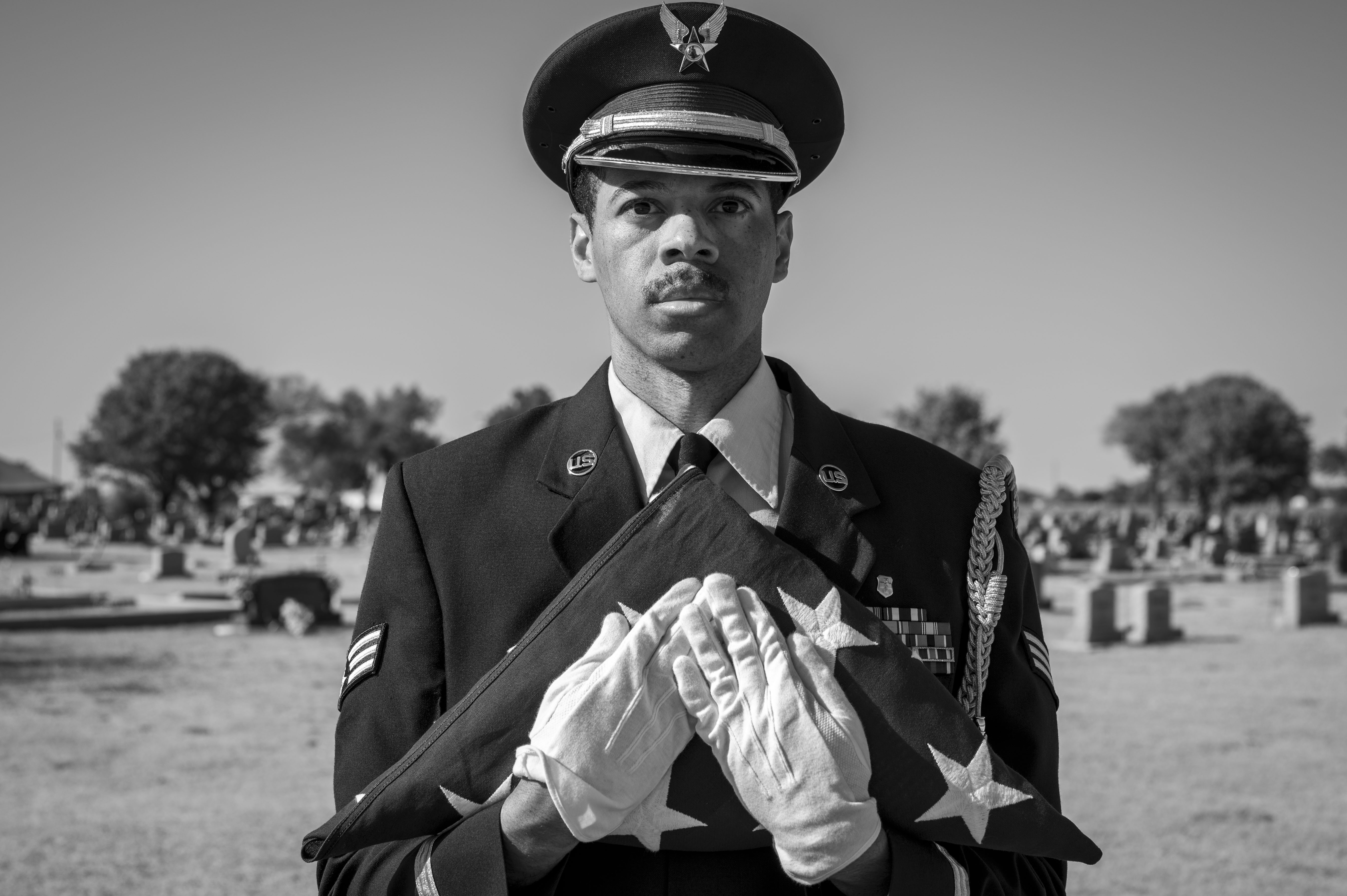 honor guard holding an american flag while facing the camera