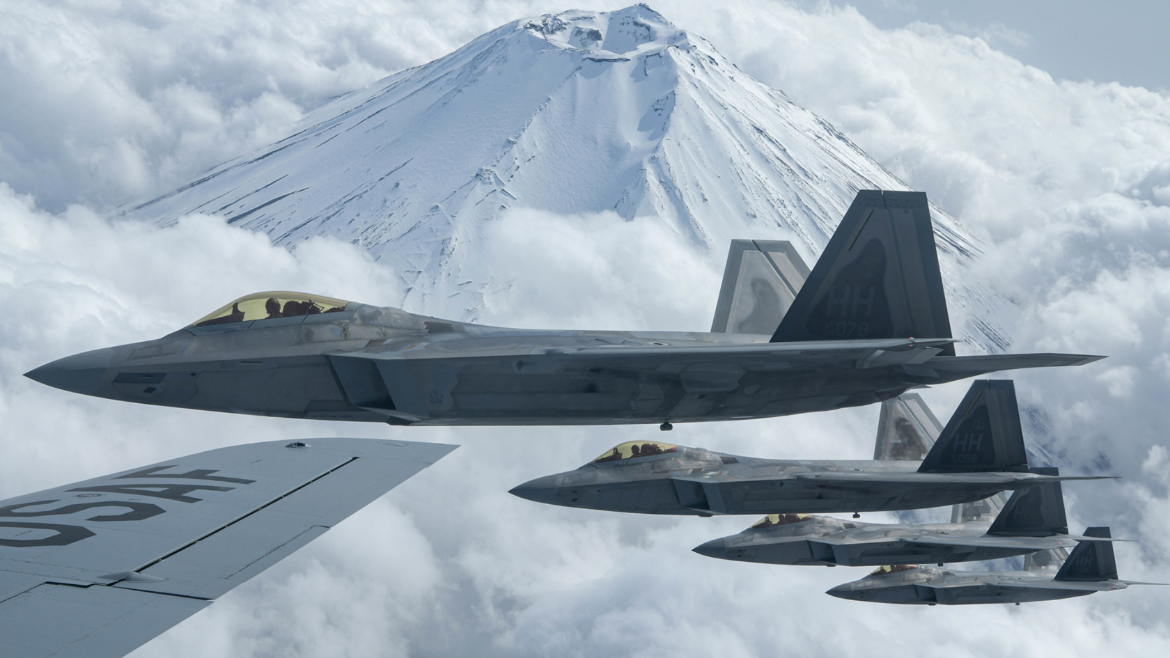 fighter jets flying over mountains