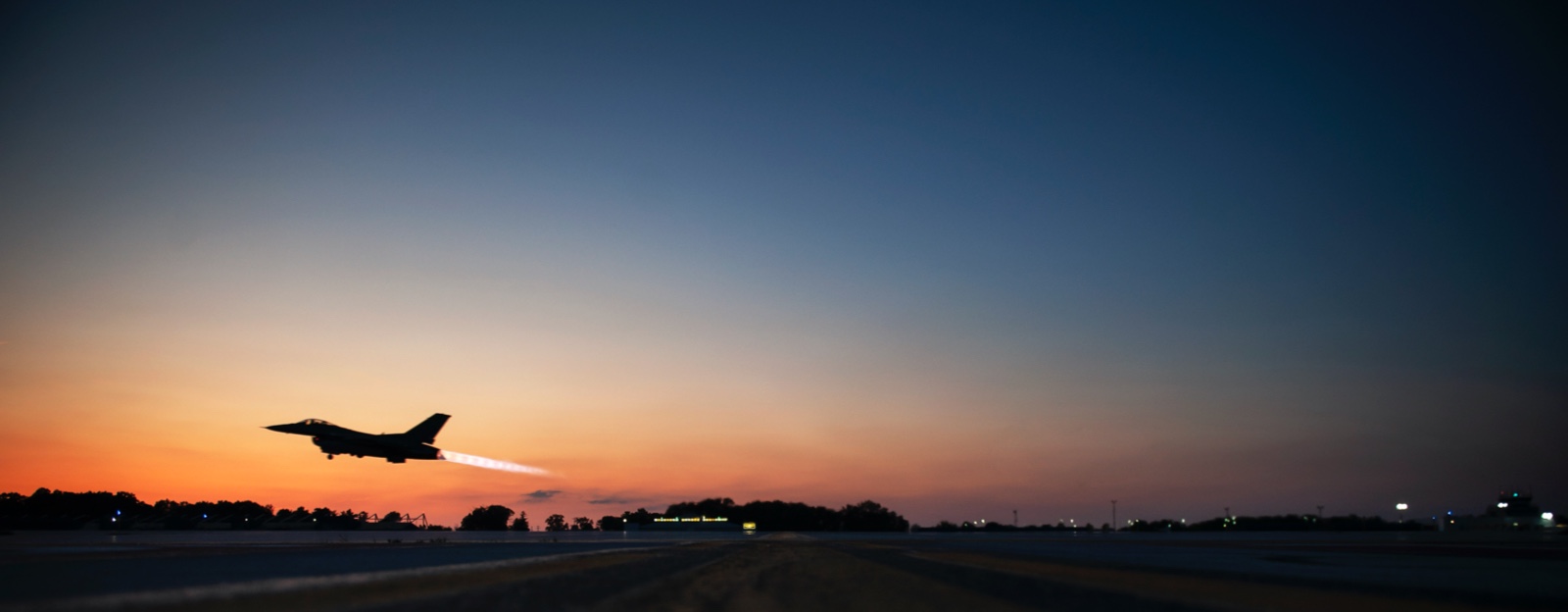 Fighter jet taking off at sunrise