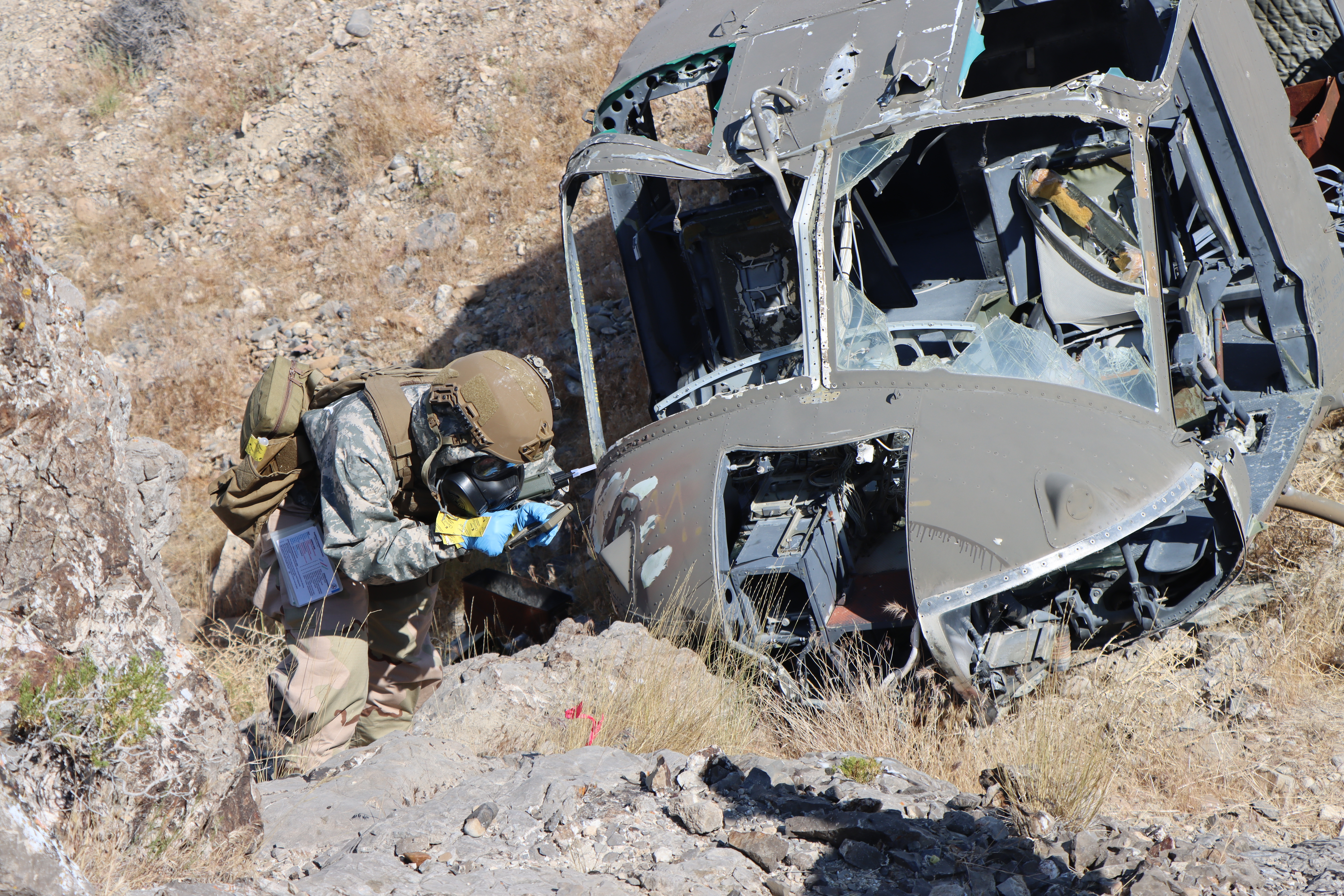 Airman in protective gear inspecting crash site