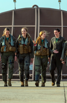 a group of four female airmen talking and walking towards the camera