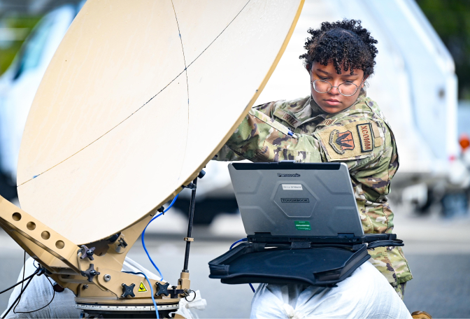 female airman adjusting satellite 