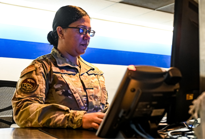 Female airman workin in front of a computer screen