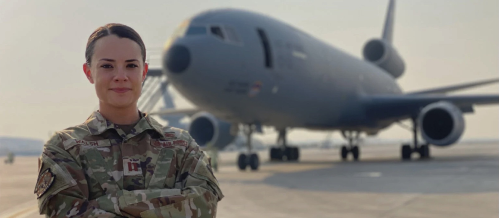 Female Airman posing in front of an aircraft