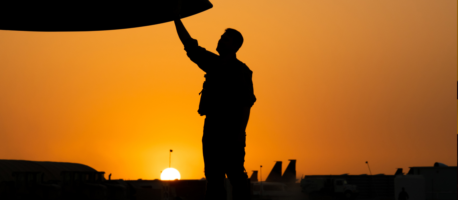 airman and aircraft at sunset