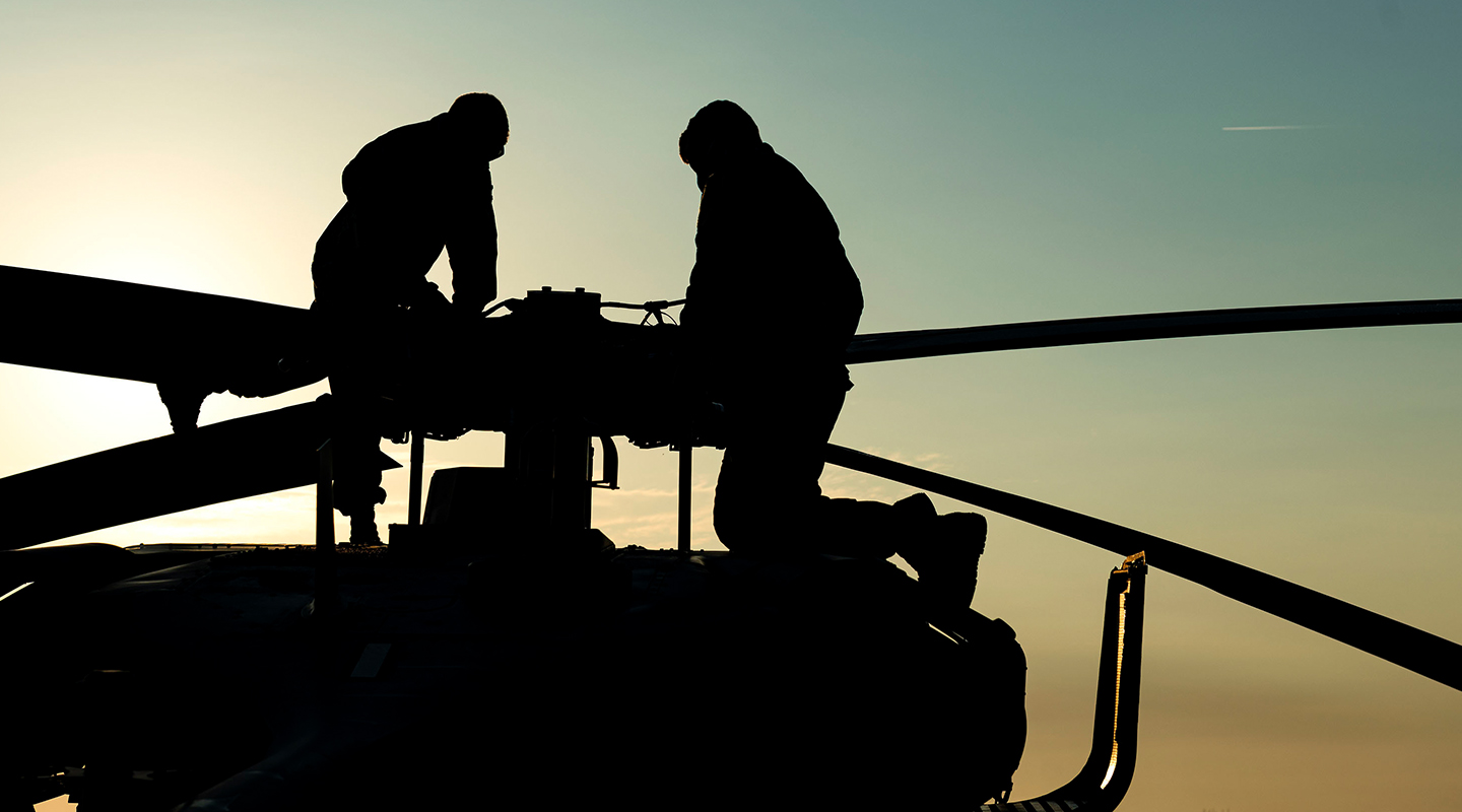 airmen on top of helicopter performing maintenance