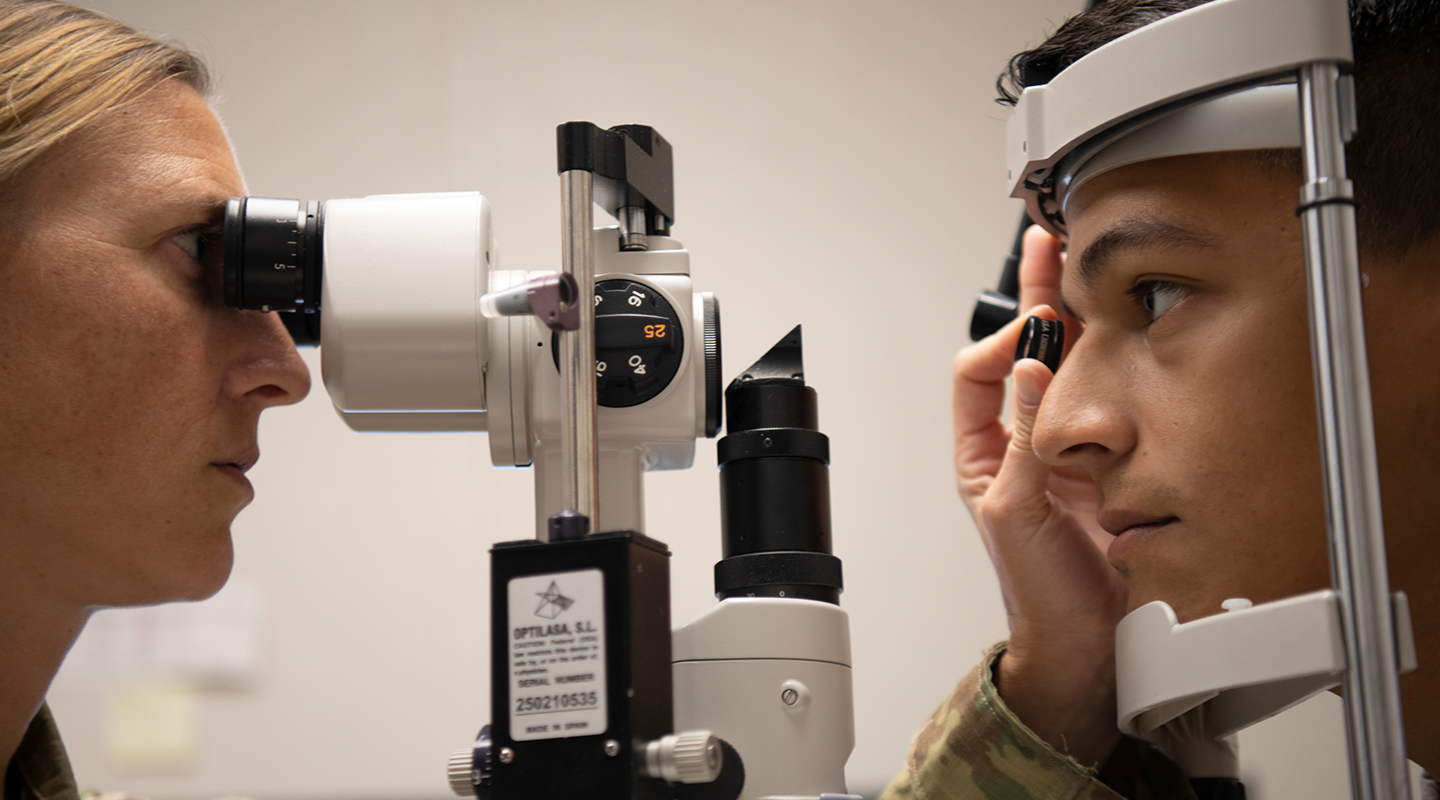 airman inspecting patient's eyes