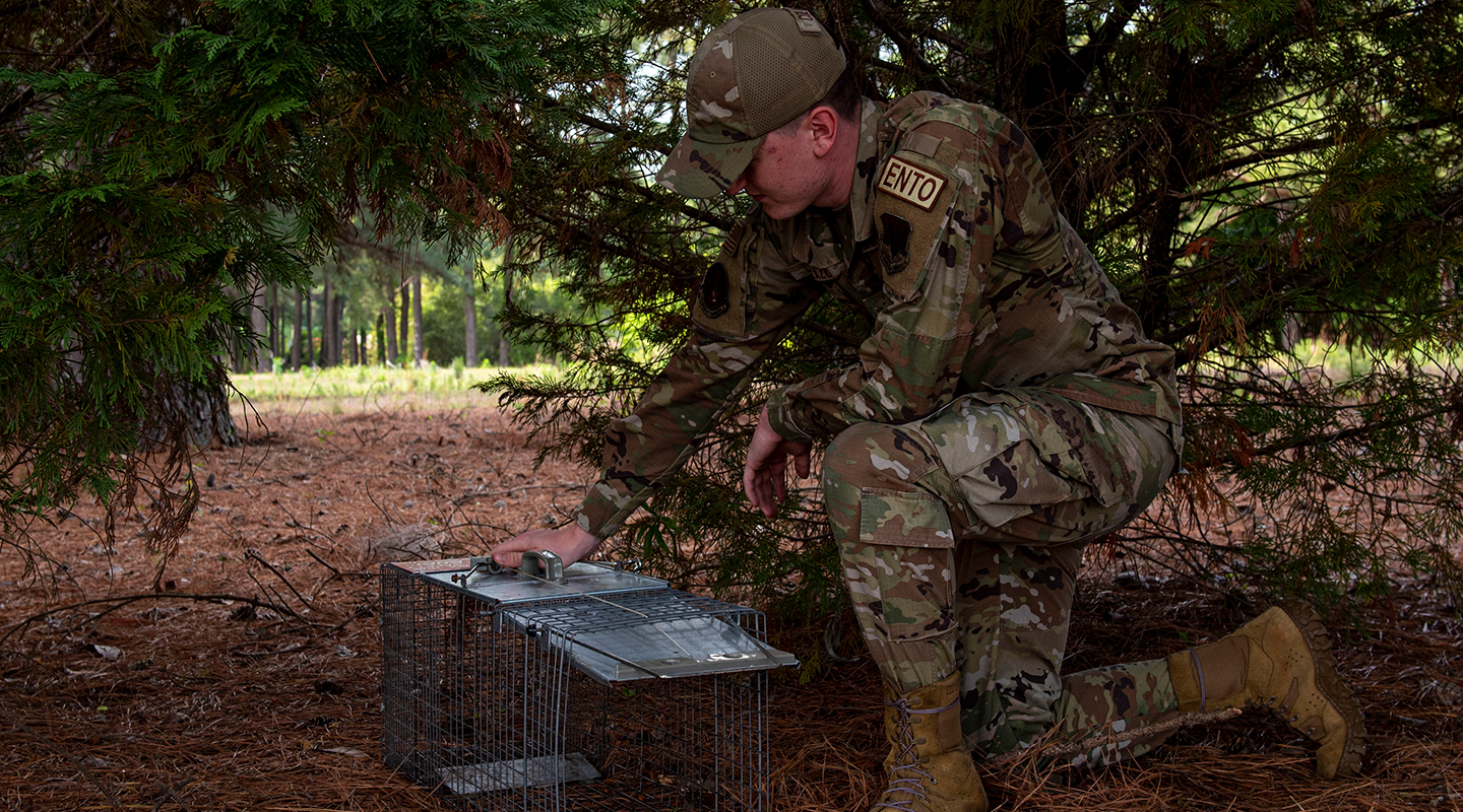 airmen with an animal cage