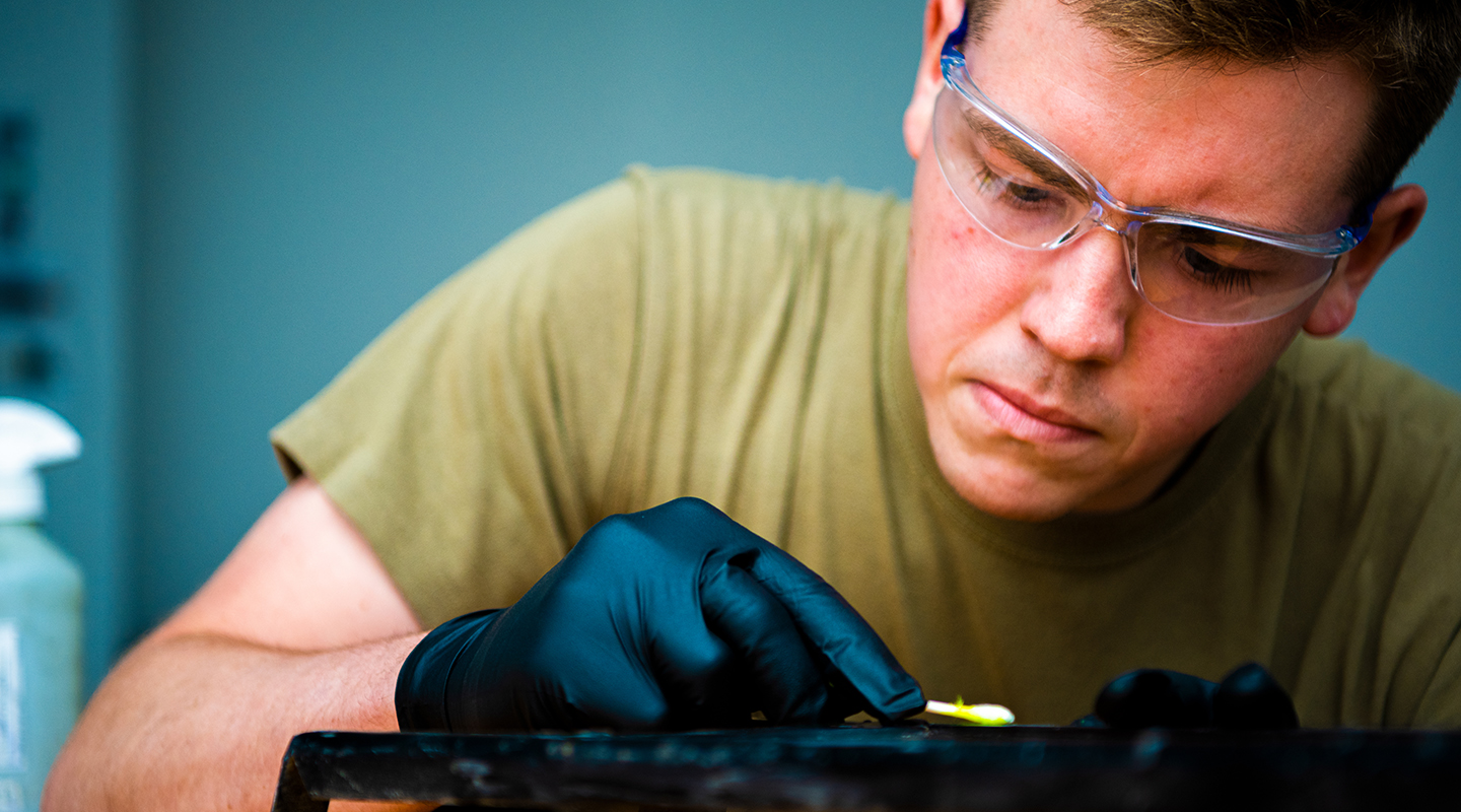 airman inspecting metal