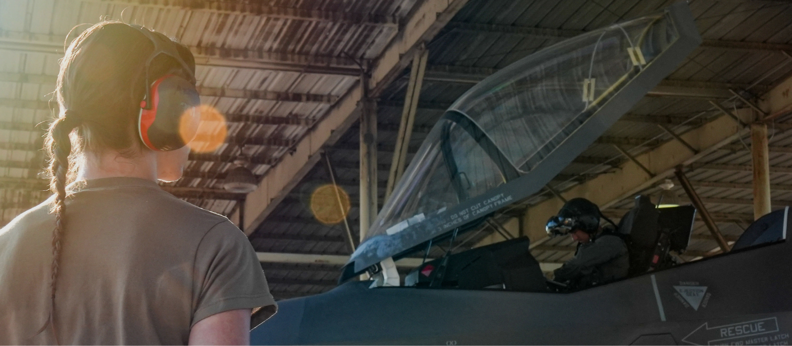 female airman wearing headphones looking at the aircraft