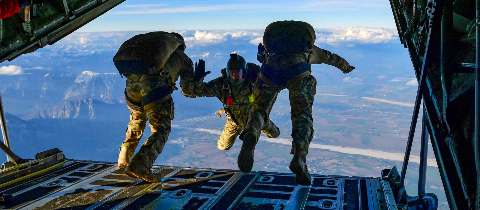 airmen jumping out of the back of an aircraft conducting training exercises