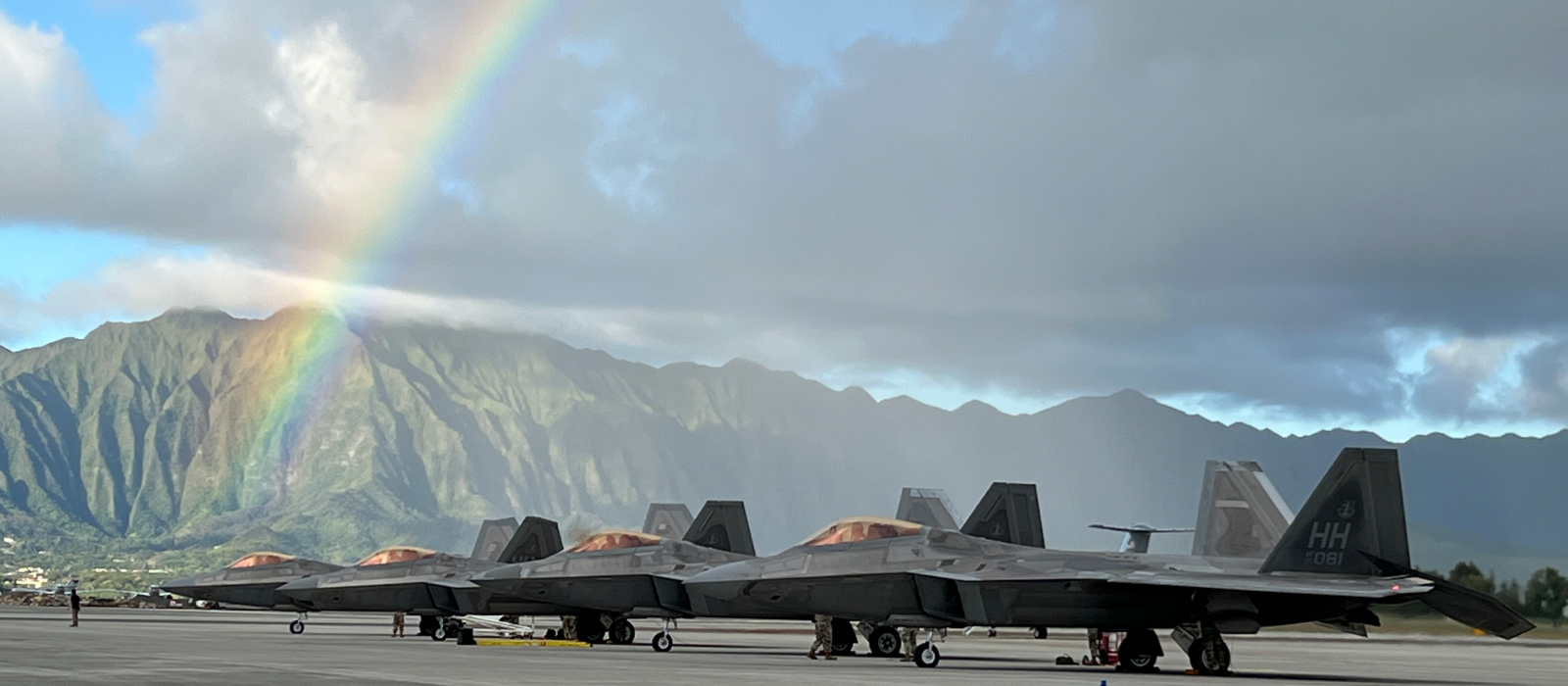 Air National Guard planes on a Hawaiian runway with rainbow and mountains