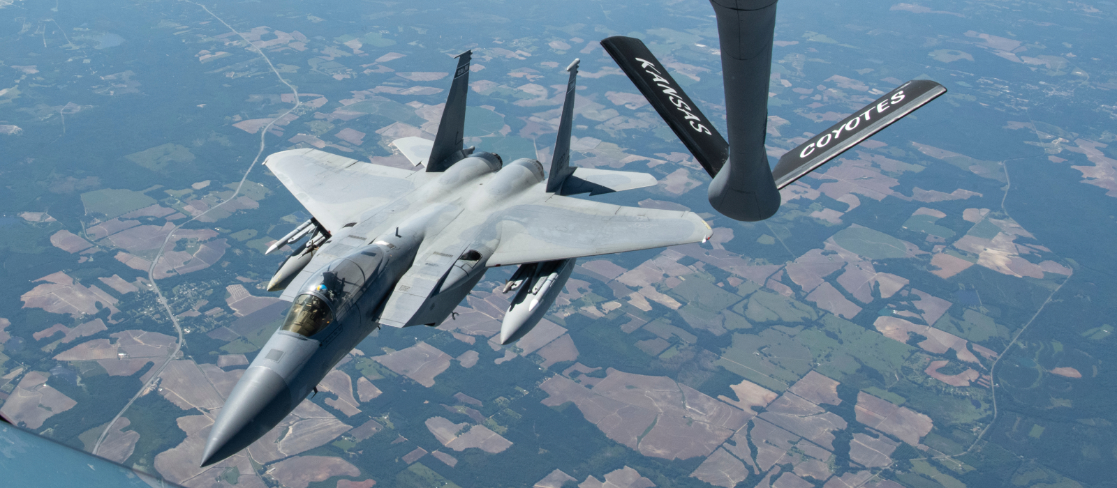 Fighter jet being refueled by an ANG plane flying over Kansas