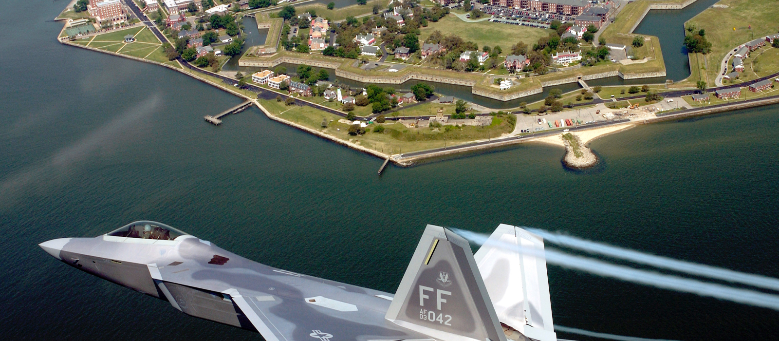 Air National Guard fighter jet flying over bay