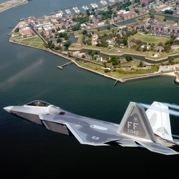 Air National Guard fighter jet flying over bay