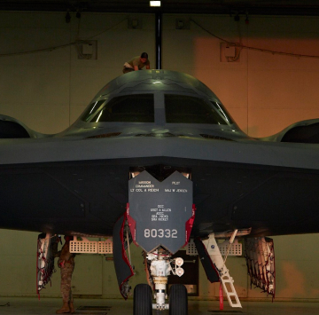 image of an aircraft in a hangar with maintainers working on it